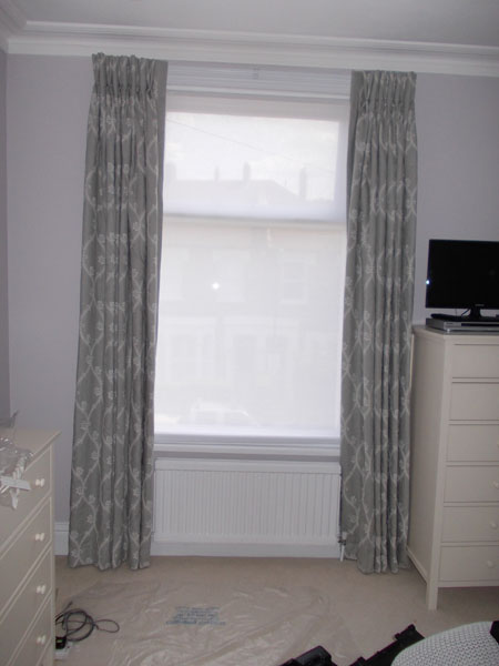 Interlined curtains, white corded curtain track and white voile roller blind for privacy