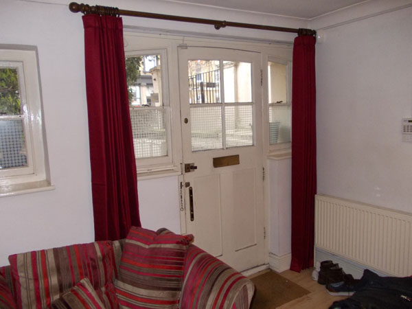 interlined curtains on wooden pole at front door