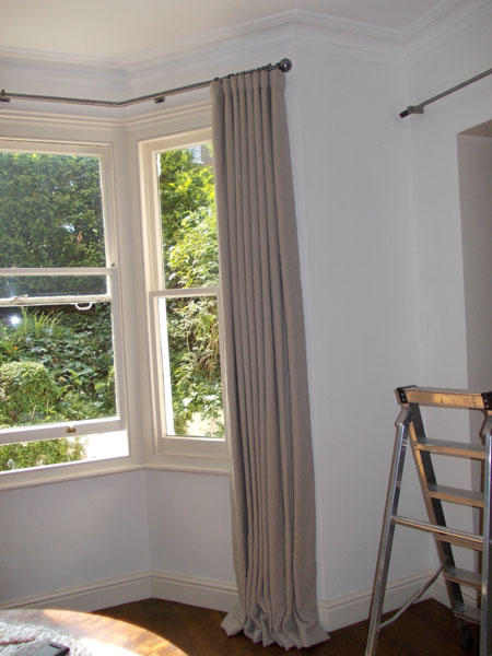 Wave style curtain hanging from pole onto floor for better draughtproofing