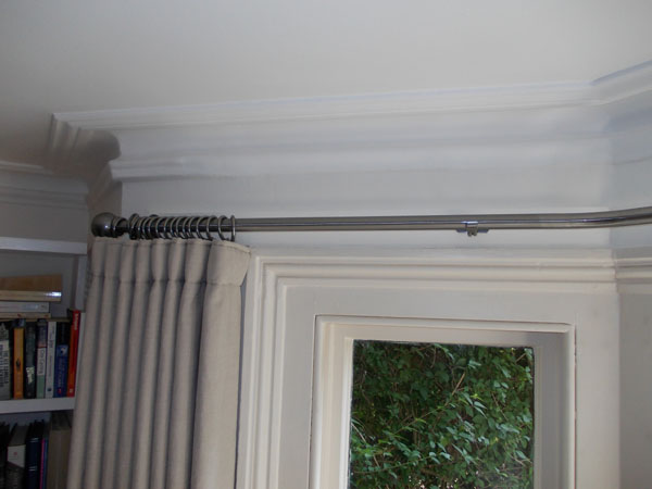 Close up of the end of a Bradley Collection pole with wave style curtain