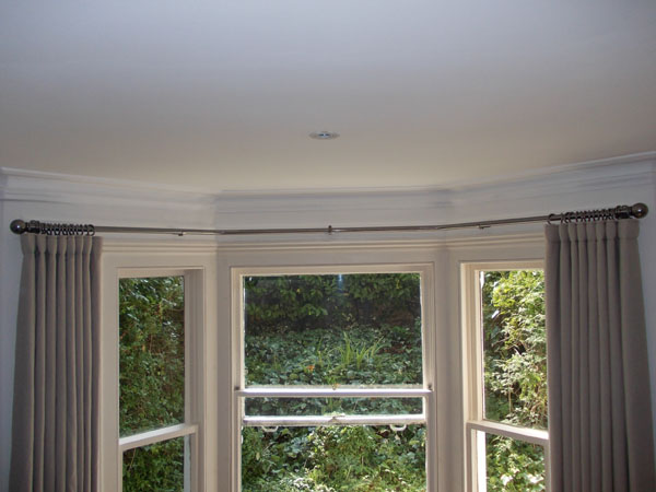 A Bradley Collection 25mm polished steel baypole with passingf brackets, passing rings and wave style curtains